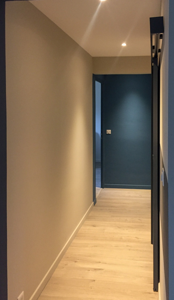Réalisation d'un couloir design avec un mur bleu et sol en stratifié.