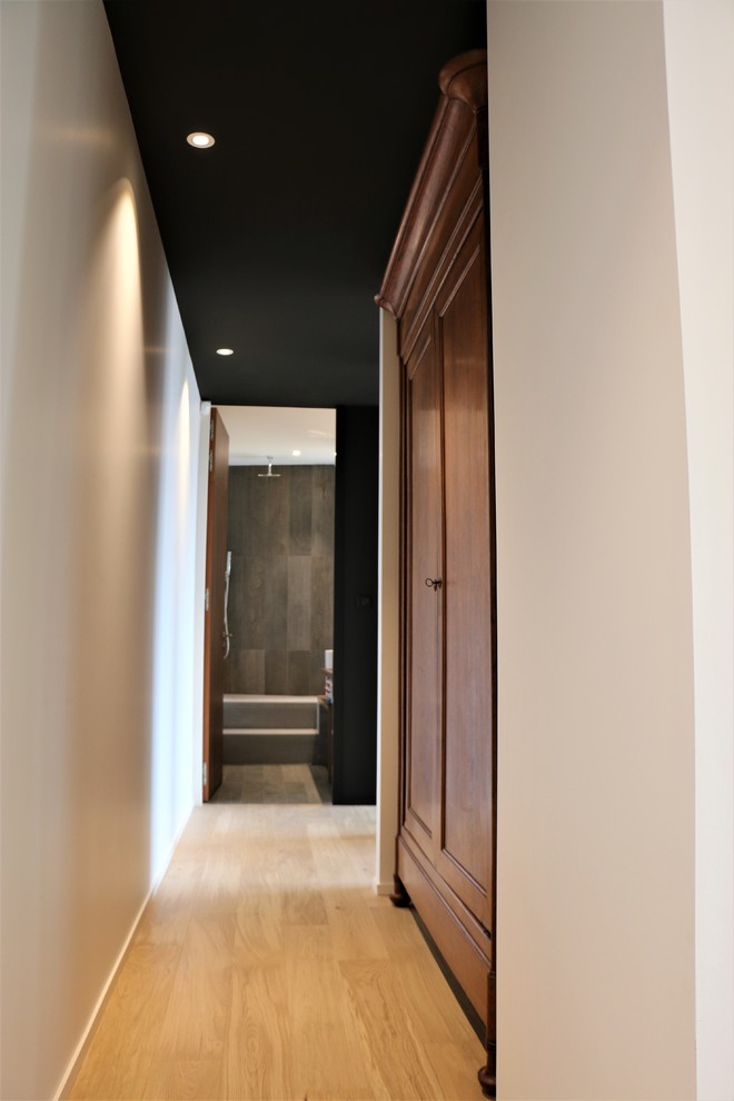 Пример оригинального дизайна: коридор среднего размера в современном стиле с черными стенами и светлым паркетным полом
