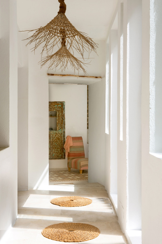 Inspiration pour un grand couloir méditerranéen avec un mur blanc et un sol beige.