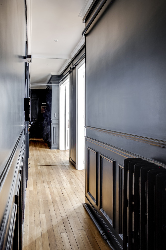 На фото: коридор в стиле неоклассика (современная классика) с черными стенами и светлым паркетным полом