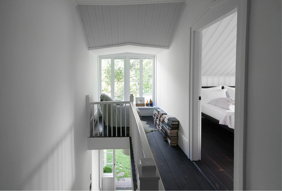 Foto på en liten skandinavisk hall, med vita väggar och mörkt trägolv