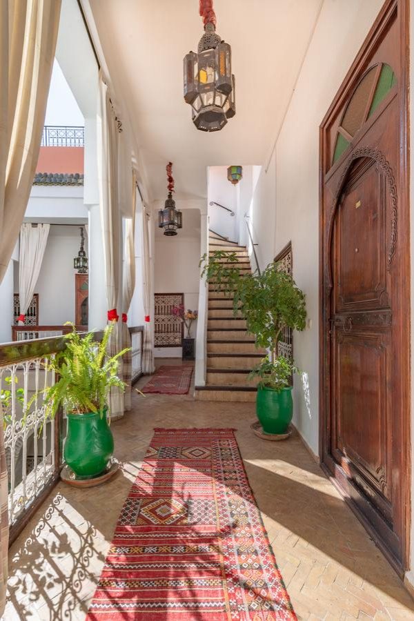 Idee per un ingresso o corridoio tropicale di medie dimensioni con pareti bianche, pavimento con piastrelle in ceramica e pavimento beige