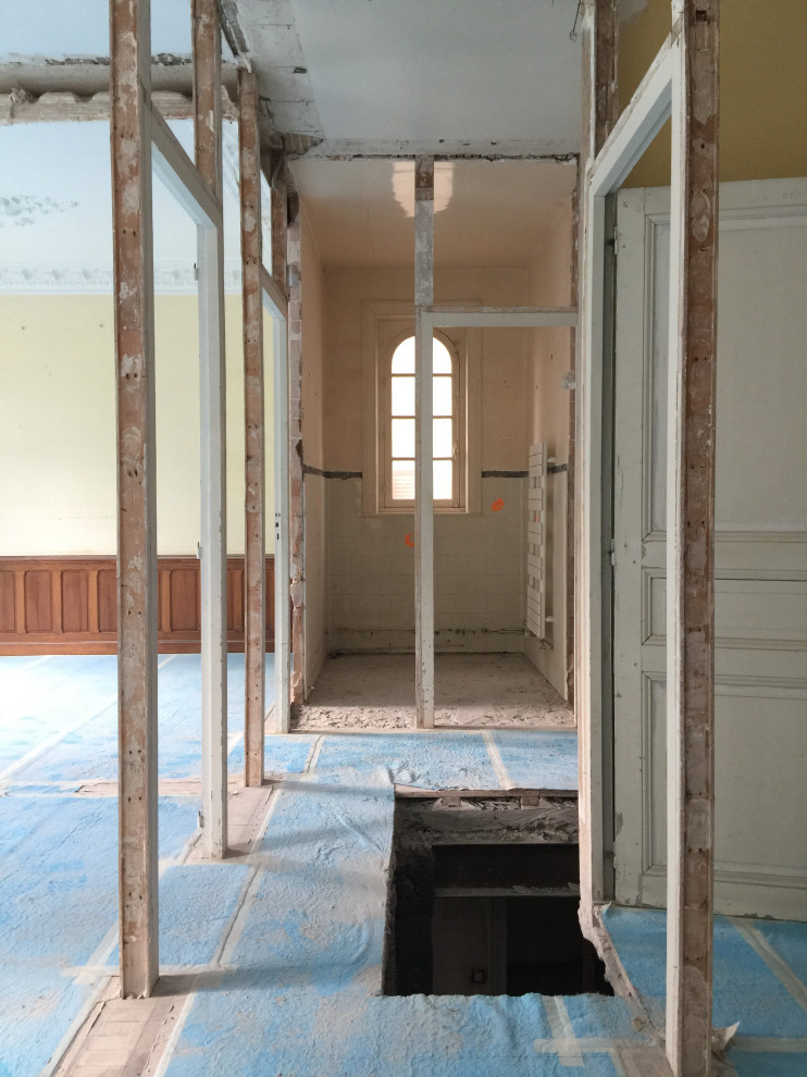 Großer Klassischer Flur mit weißer Wandfarbe, hellem Holzboden, beigem Boden, eingelassener Decke und vertäfelten Wänden in Rennes