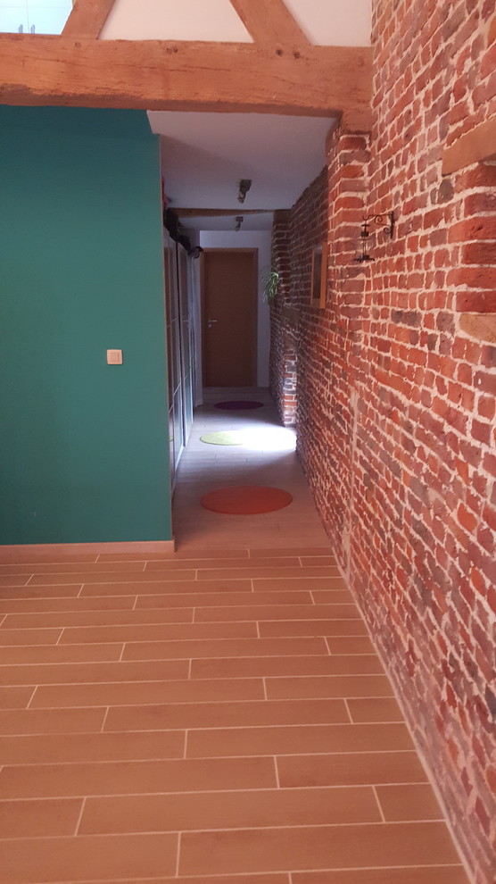 Cette image montre un grand couloir minimaliste avec un mur rouge.
