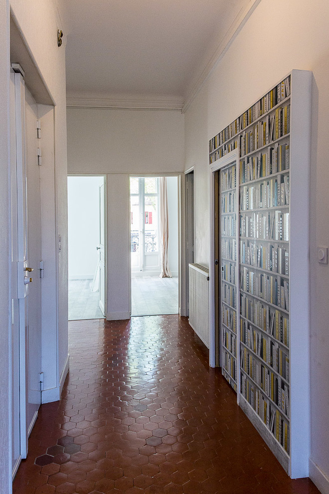 На фото: коридор среднего размера в современном стиле с белыми стенами, полом из терракотовой плитки и красным полом