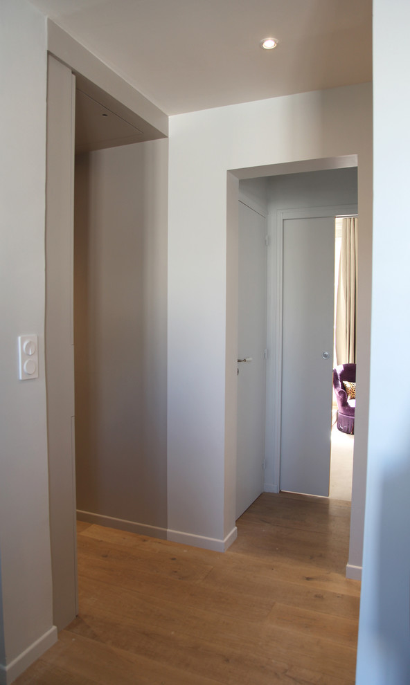 Réalisation d'un petit couloir design avec un mur beige et parquet clair.