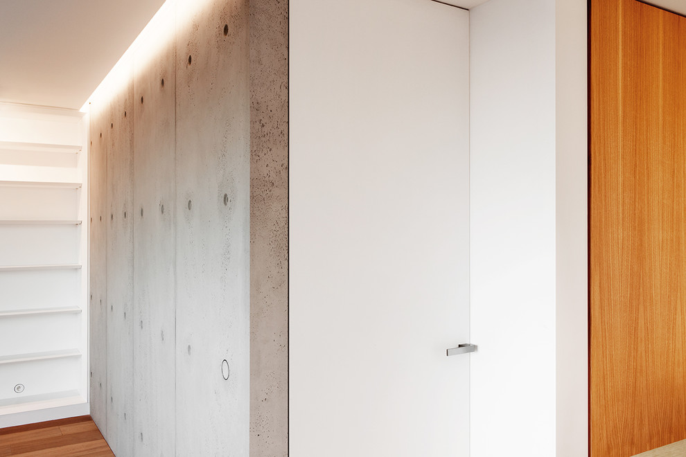 Imagen de recibidores y pasillos actuales de tamaño medio con paredes blancas, suelo de madera clara y suelo marrón