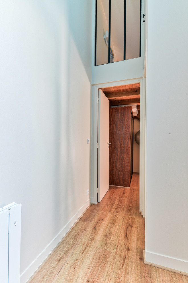 Imagen de recibidores y pasillos minimalistas con paredes beige y suelo de madera clara