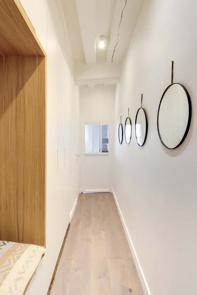 Idée de décoration pour un petit couloir design avec un mur blanc, parquet foncé et un sol marron.
