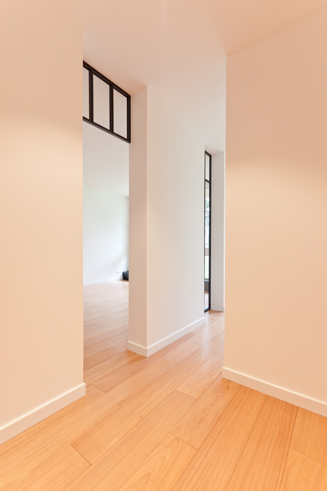 Idée de décoration pour un petit couloir tradition avec un mur blanc et parquet clair.
