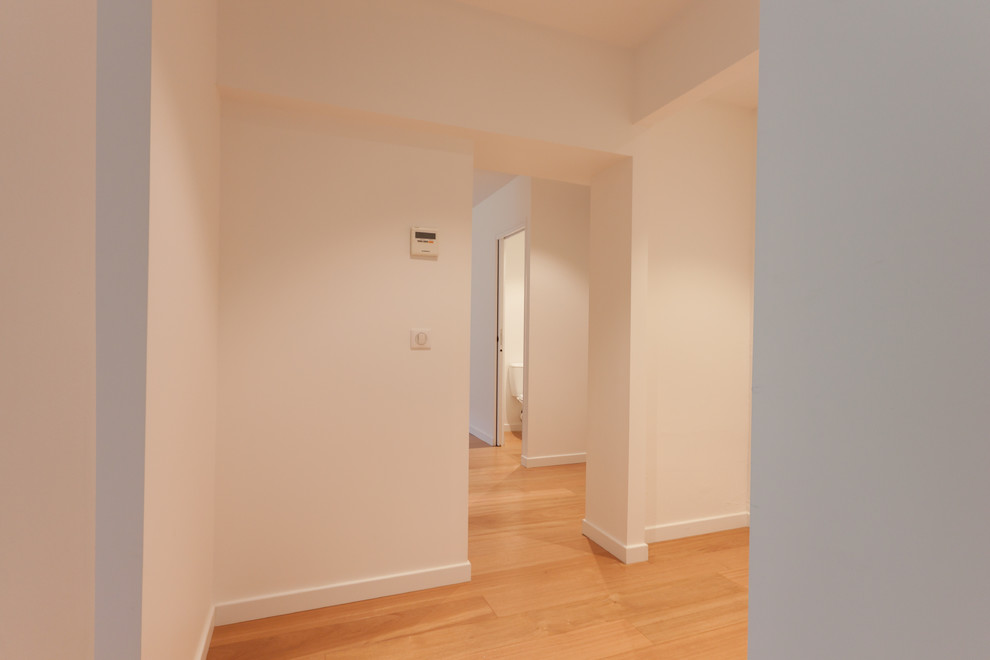 Réalisation d'un petit couloir tradition avec un mur blanc et parquet clair.
