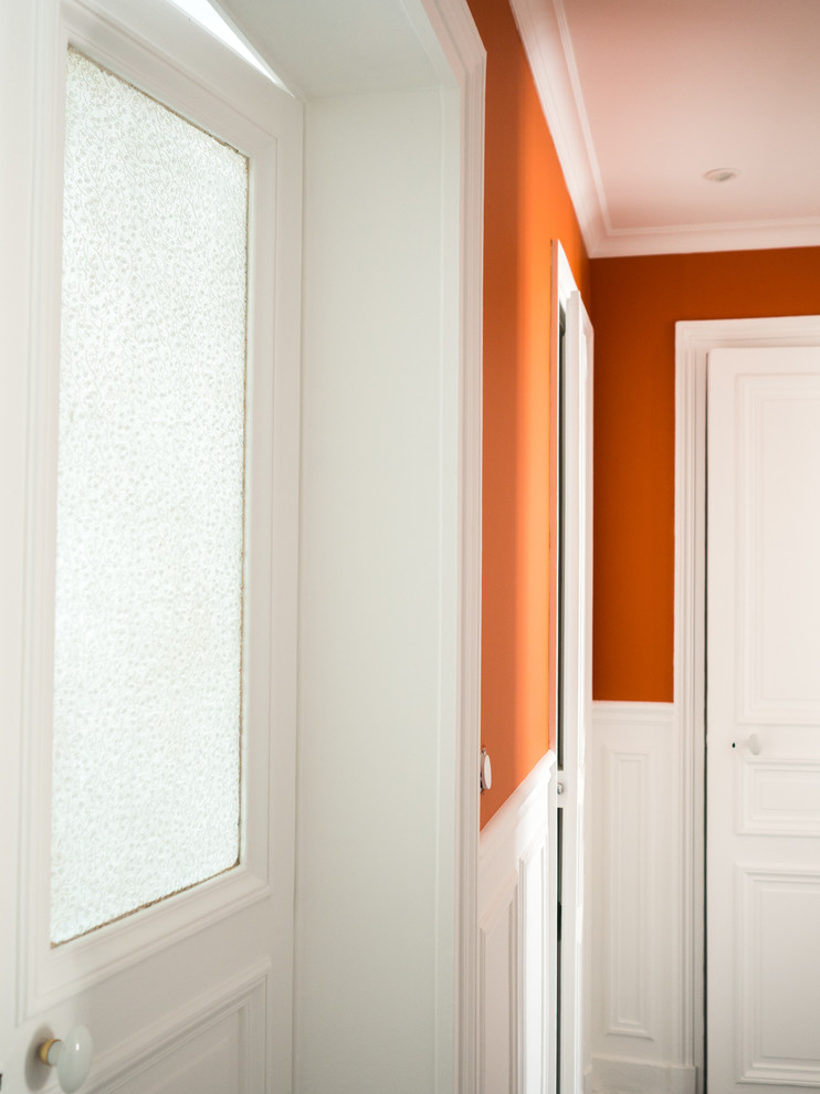 Idee per un grande ingresso o corridoio tradizionale con pareti arancioni, parquet chiaro e pavimento marrone