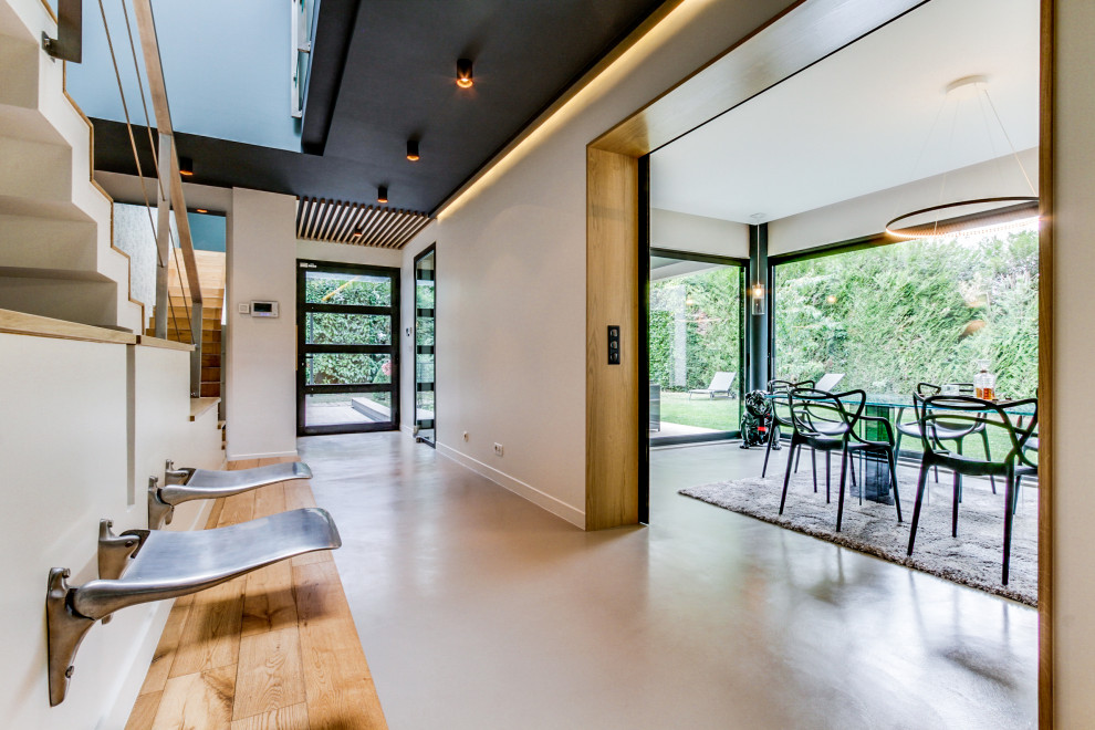 Идея дизайна: коридор в современном стиле с бежевыми стенами, бетонным полом, серым полом и деревянными стенами