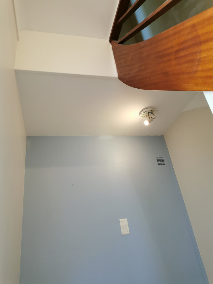 Ispirazione per un piccolo ingresso o corridoio minimalista con pareti blu, pavimento in terracotta e pavimento beige