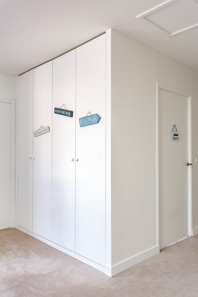 Imagen de recibidores y pasillos minimalistas de tamaño medio con paredes blancas, moqueta y suelo beige
