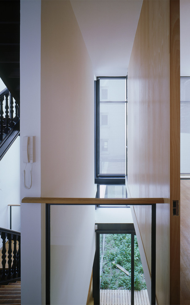 Modelo de recibidores y pasillos contemporáneos con paredes blancas y suelo de madera clara