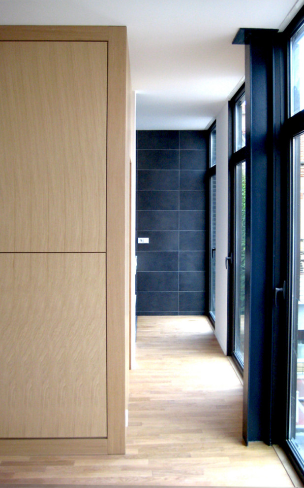 Ejemplo de recibidores y pasillos contemporáneos con paredes blancas y suelo de madera clara