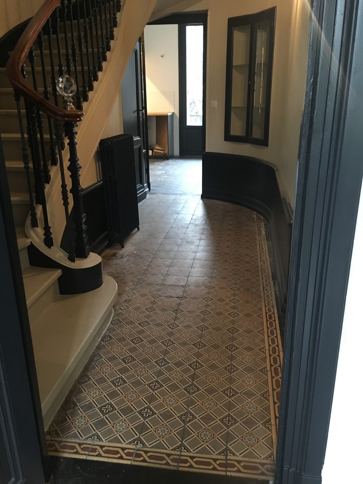 На фото: коридор среднего размера в викторианском стиле с белыми стенами, полом из керамической плитки и серым полом