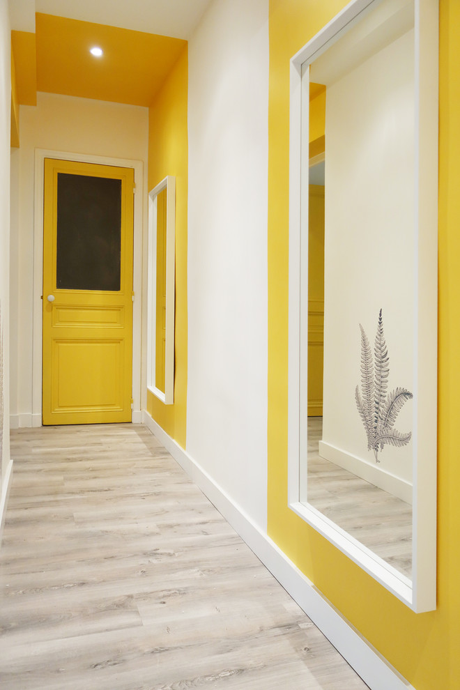 На фото: коридор в скандинавском стиле с желтыми стенами и паркетным полом среднего тона