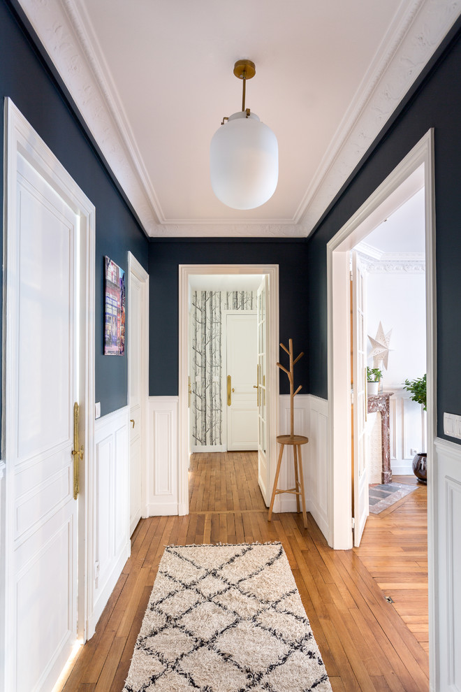 Ejemplo de recibidores y pasillos de tamaño medio con suelo de madera en tonos medios, suelo beige y paredes azules