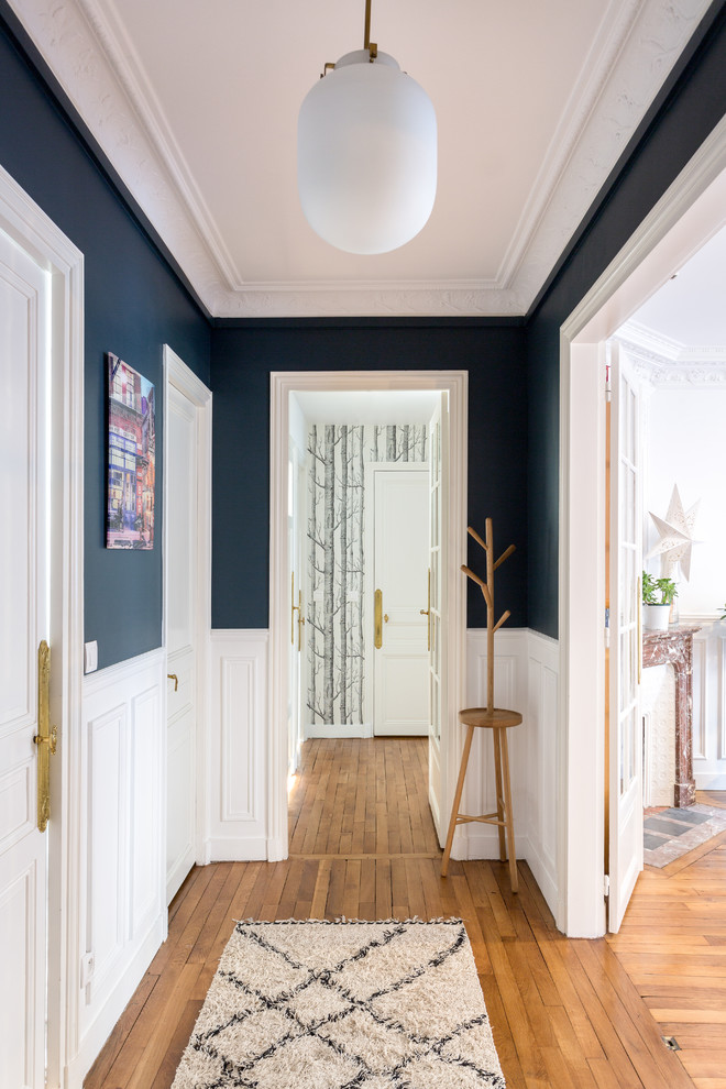 Idées déco pour un couloir contemporain de taille moyenne avec un mur multicolore, un sol en bois brun et un sol beige.