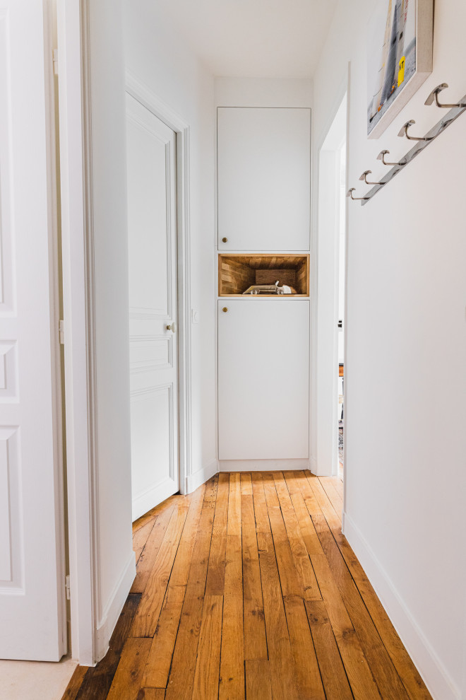 Idée de décoration pour un petit couloir tradition avec un mur blanc, parquet clair et un sol marron.
