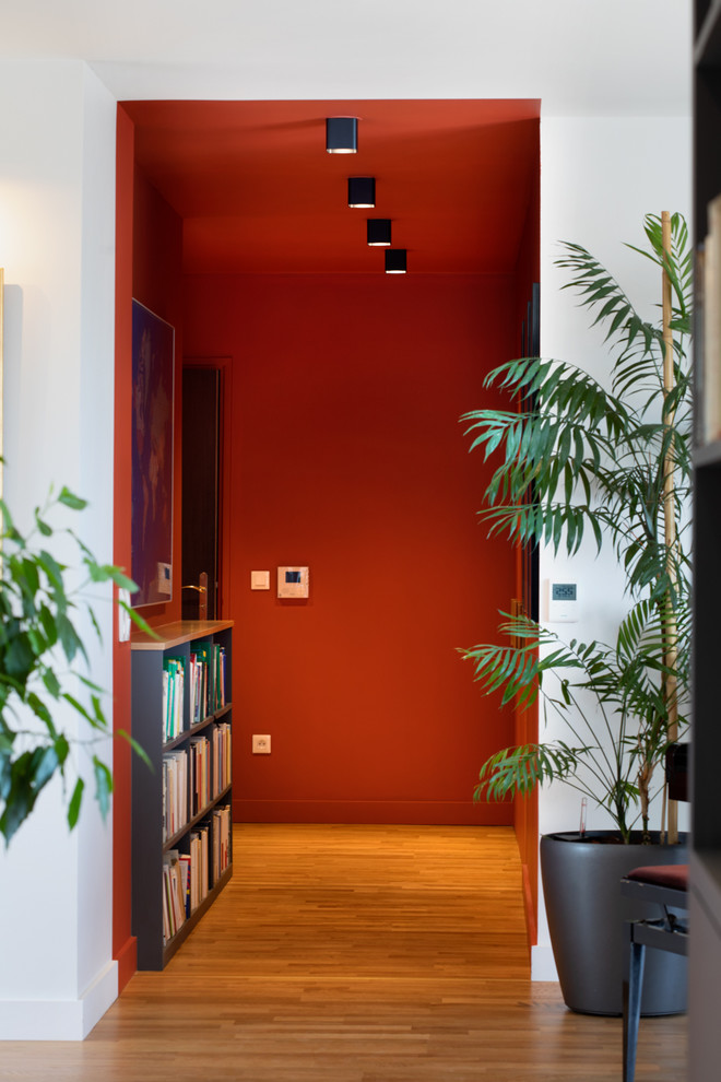 Modern inredning av en hall, med orange väggar och ljust trägolv