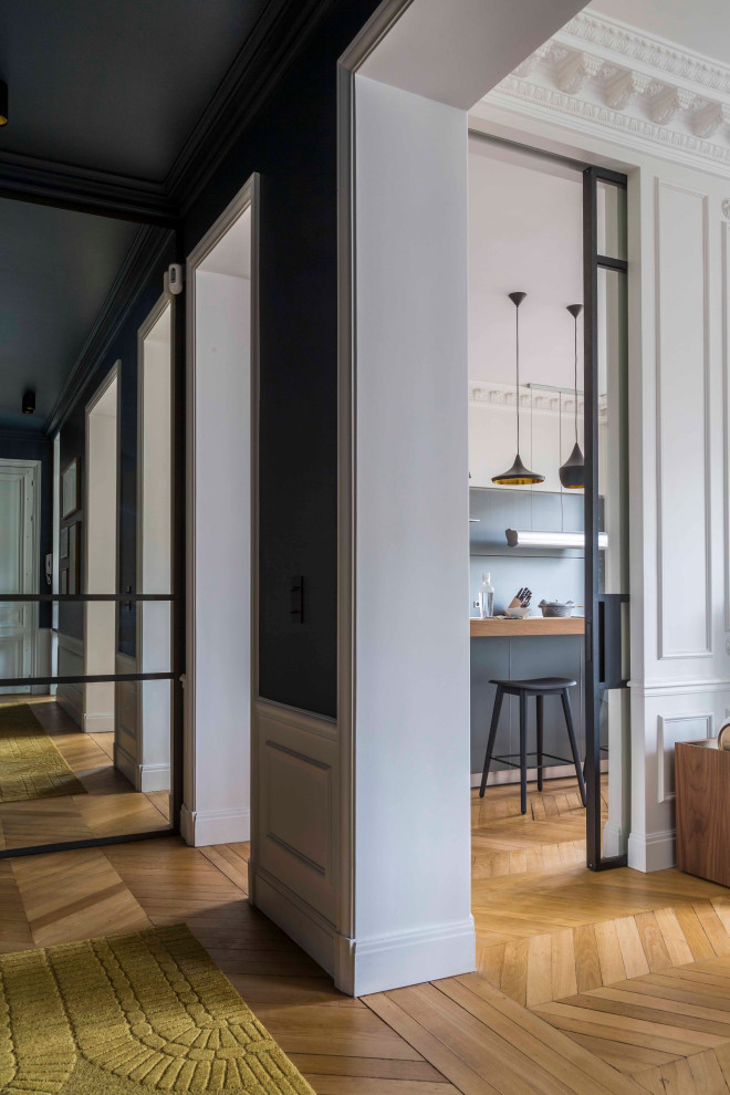 Großer Klassischer Flur mit schwarzer Wandfarbe, hellem Holzboden und beigem Boden in Paris