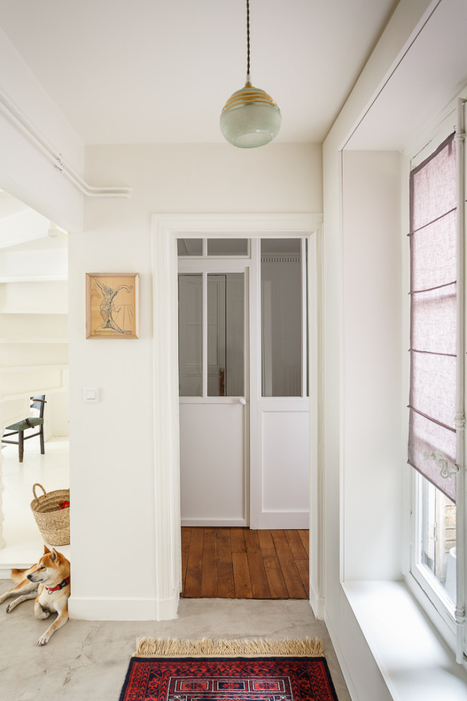 Idée de décoration pour un couloir tradition de taille moyenne avec un mur blanc, sol en béton ciré et un sol gris.