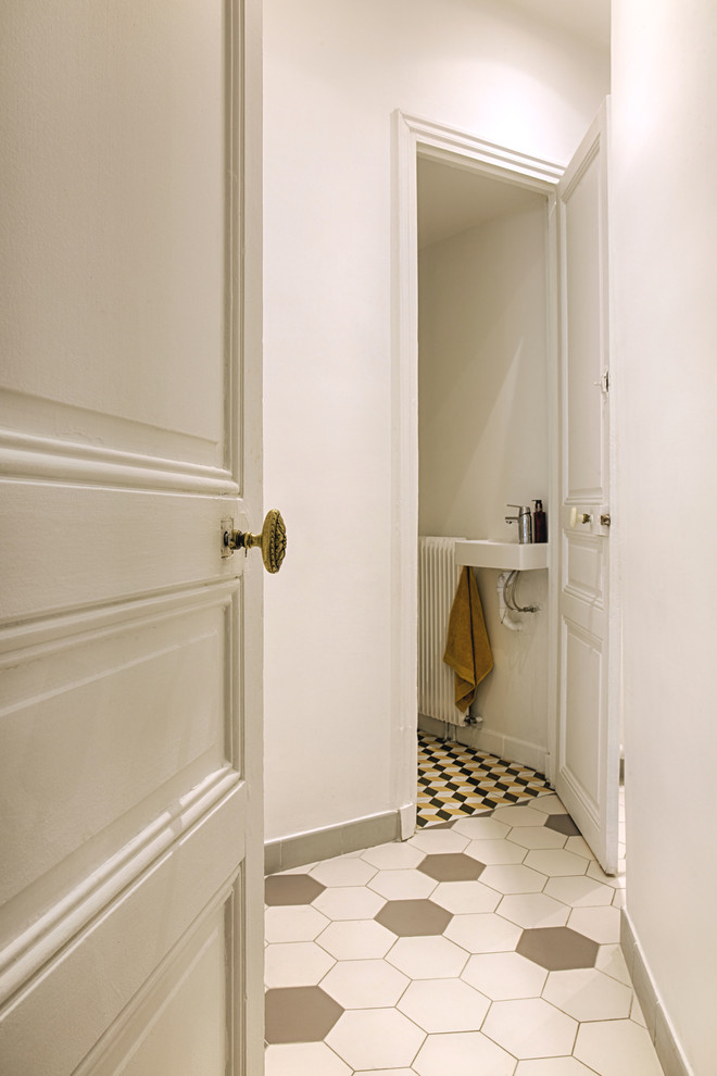 Exemple d'un couloir chic de taille moyenne avec un mur blanc, un sol en carrelage de céramique et un sol blanc.