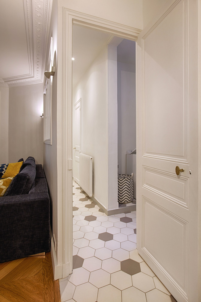 На фото: коридор среднего размера в классическом стиле с белыми стенами, полом из керамической плитки и белым полом с