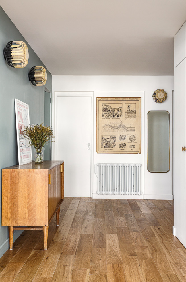 Réalisation d'un couloir minimaliste de taille moyenne avec un mur vert, un sol en bois brun et un sol marron.