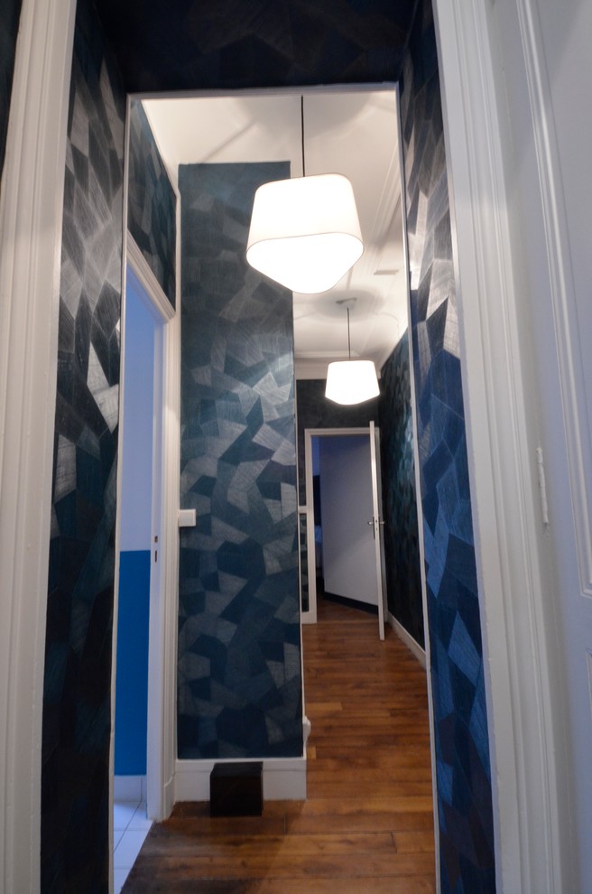 Imagen de recibidores y pasillos contemporáneos pequeños con paredes azules y suelo de madera clara