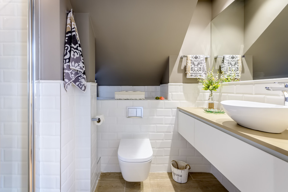 Inspiration för ett mellanstort funkis beige beige badrum med dusch, med släta luckor, vita skåp, en vägghängd toalettstol, vit kakel, ljust trägolv, ett fristående handfat, en dusch i en alkov, tunnelbanekakel och bruna väggar