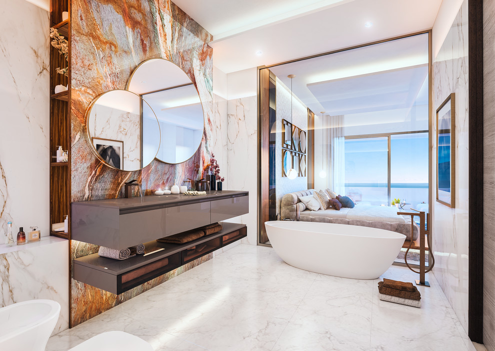 Inredning av ett modernt grå grått en-suite badrum, med ett fristående badkar, marmorkakel, marmorgolv, ett integrerad handfat, släta luckor, grå skåp, orange kakel, vit kakel och vitt golv