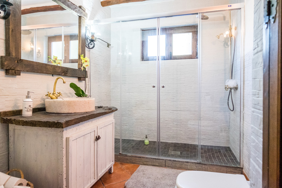 Idéer för mellanstora nordiska badrum med dusch, med luckor med upphöjd panel, beige skåp, en dusch i en alkov, en toalettstol med hel cisternkåpa, vita väggar, klinkergolv i terrakotta, ett fristående handfat och träbänkskiva