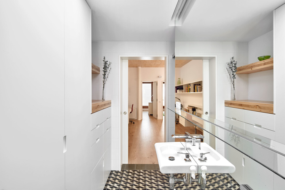 Imagen de cuarto de baño escandinavo de tamaño medio con armarios con paneles lisos, puertas de armario blancas, aseo y ducha y lavabo suspendido