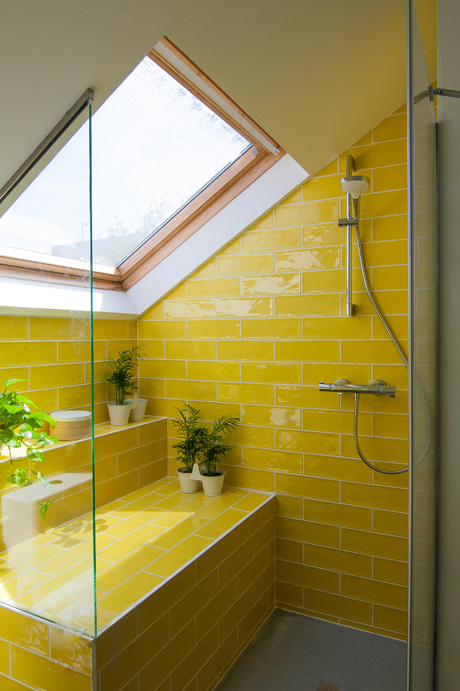 Foto de cuarto de baño nórdico con ducha empotrada, baldosas y/o azulejos amarillos, baldosas y/o azulejos de cemento, paredes amarillas y suelo gris