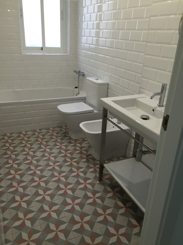 Идея дизайна: главная ванная комната среднего размера в скандинавском стиле с ванной в нише, душем над ванной, биде, белой плиткой, керамической плиткой, белыми стенами, полом из керамической плитки и консольной раковиной
