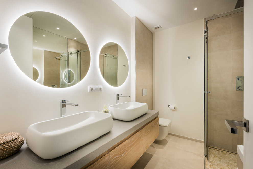 Foto di una stanza da bagno con doccia design con ante lisce, ante in legno chiaro, doccia ad angolo, WC sospeso, piastrelle beige, pareti bianche, lavabo a bacinella, pavimento beige e top grigio