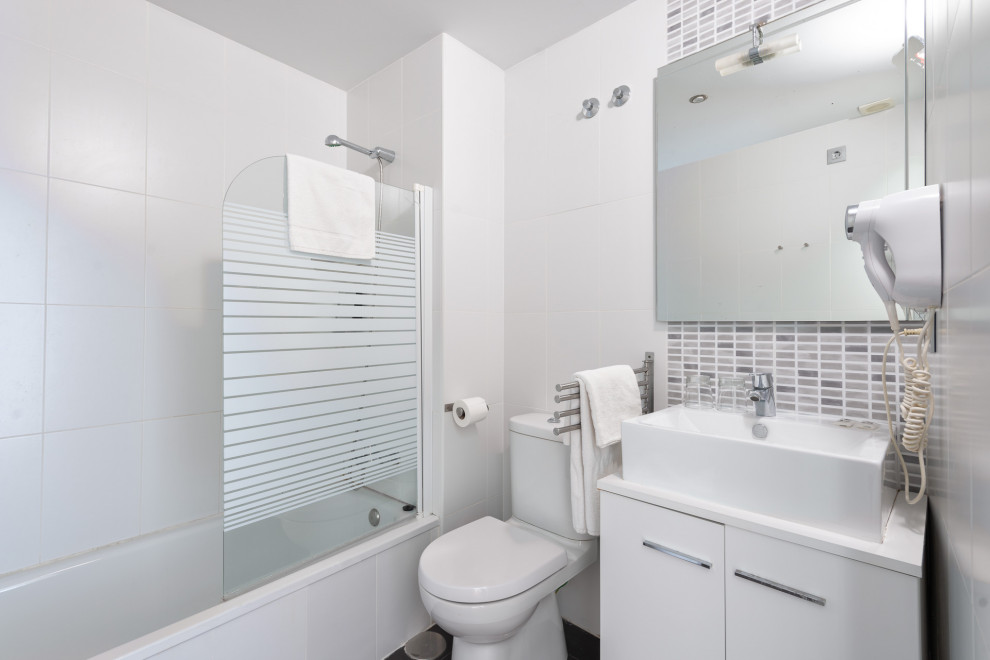 Modern inredning av ett mellanstort vit vitt badrum med dusch, med släta luckor, vita skåp, ett badkar i en alkov, en dusch/badkar-kombination, en toalettstol med separat cisternkåpa, grå kakel, vit kakel, porslinskakel och röda väggar