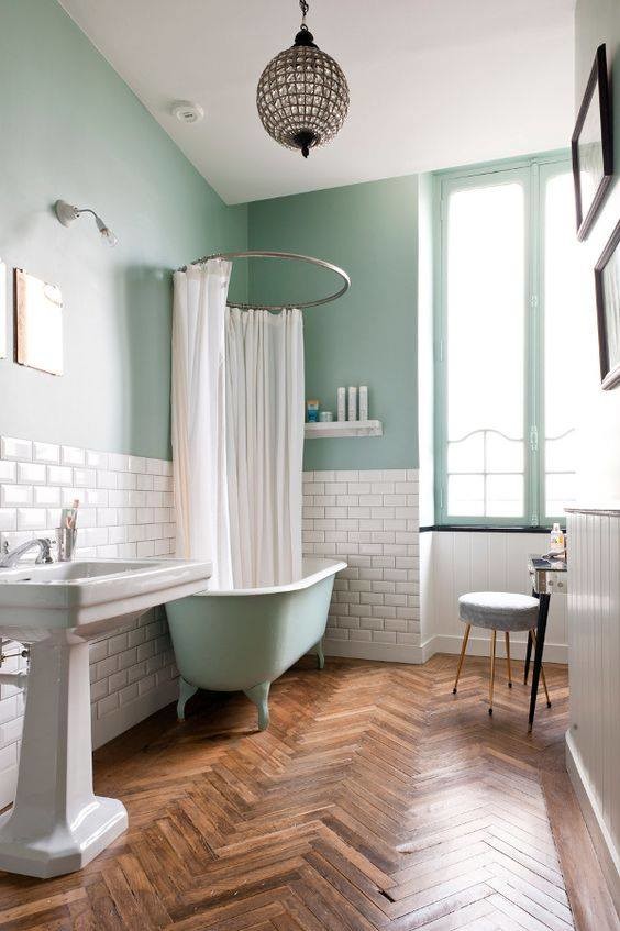 Foto de cuarto de baño principal retro de tamaño medio con bañera con patas, combinación de ducha y bañera, paredes azules, suelo de madera en tonos medios y lavabo con pedestal