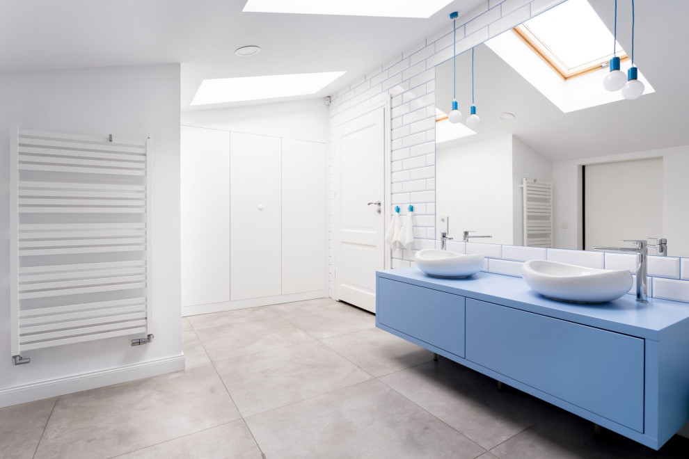 Diseño de cuarto de baño doble y flotante escandinavo con armarios con paneles lisos, puertas de armario azules, baldosas y/o azulejos blancos, baldosas y/o azulejos de cemento, paredes blancas, lavabo sobreencimera, suelo gris y encimeras azules