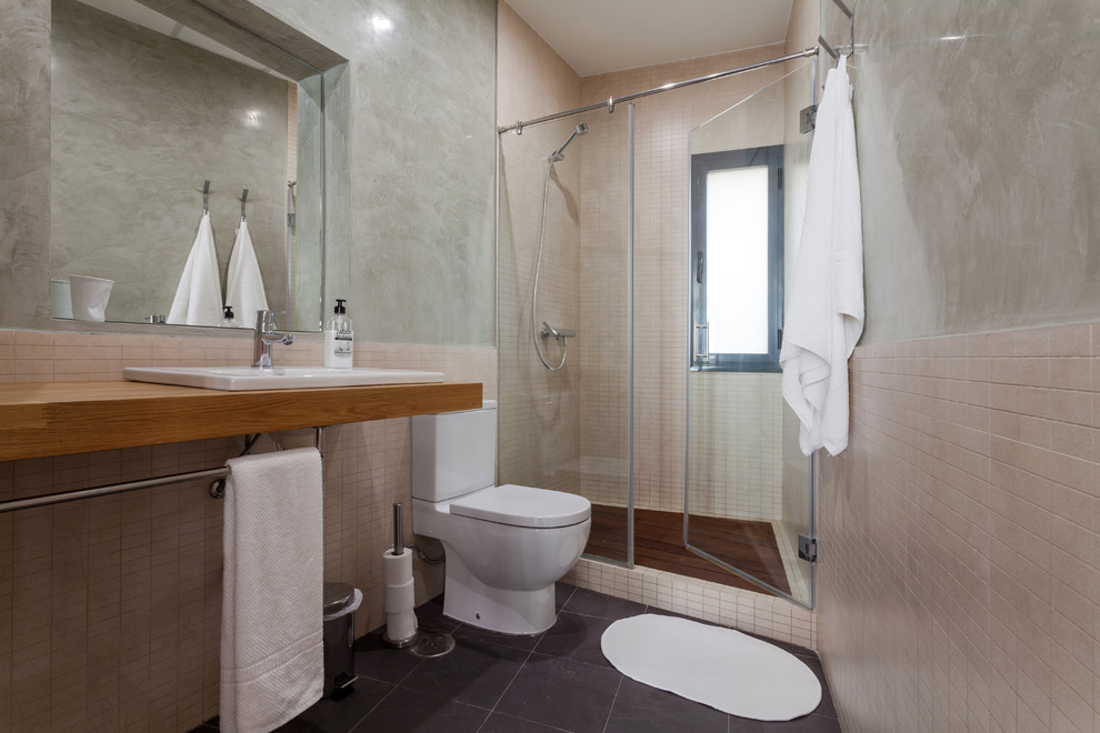Ejemplo de cuarto de baño contemporáneo de tamaño medio con ducha empotrada, sanitario de dos piezas, paredes beige, suelo de baldosas de cerámica, aseo y ducha, lavabo encastrado y encimera de madera