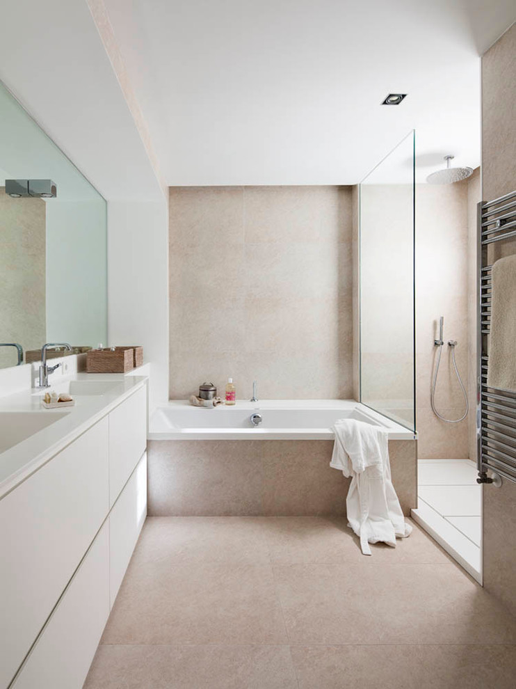 Idéer för stora minimalistiska en-suite badrum, med släta luckor, vita skåp, ett badkar i en alkov, en kantlös dusch, beige kakel, stenkakel, beige väggar, kalkstensgolv, ett integrerad handfat och bänkskiva i kvarts