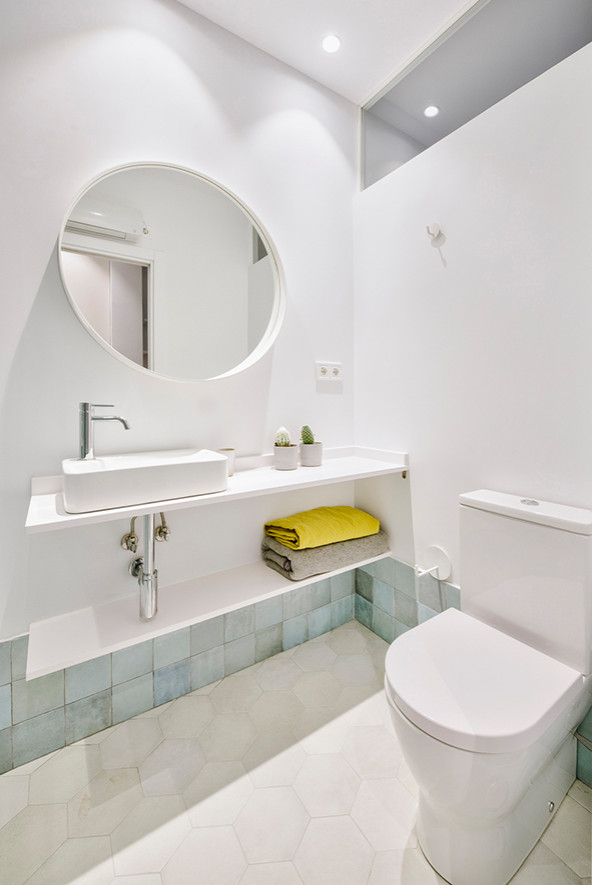 Foto på ett litet funkis vit en-suite badrum, med vita skåp, en dusch i en alkov, en vägghängd toalettstol, blå kakel, keramikplattor, vita väggar, klinkergolv i porslin, ett fristående handfat, bänkskiva i kvarts, vitt golv och dusch med skjutdörr