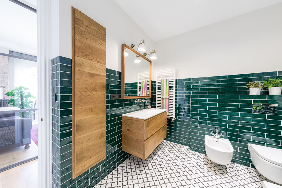 Foto på ett mellanstort funkis badrum med dusch, med släta luckor, skåp i mellenmörkt trä, keramikplattor, träbänkskiva, ett platsbyggt badkar, en dusch/badkar-kombination, en toalettstol med separat cisternkåpa, grön kakel, gröna väggar, klinkergolv i terrakotta, ett väggmonterat handfat, grått golv och med dusch som är öppen