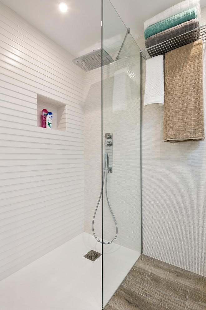 Идея дизайна: ванная комната в стиле модернизм с светлыми деревянными фасадами, душем без бортиков, писсуаром, белой плиткой, керамогранитной плиткой, белыми стенами, полом из керамогранита, душевой кабиной и врезной раковиной