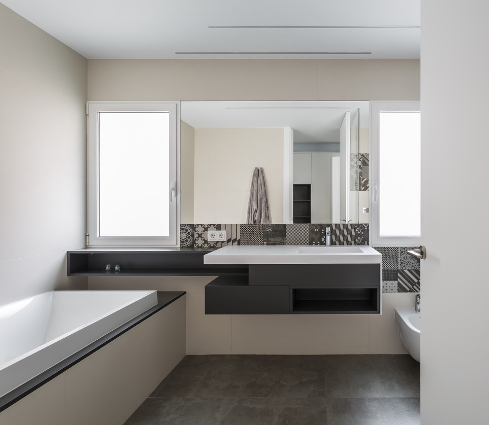 Esempio di una stanza da bagno contemporanea con lavabo sospeso, ante lisce, ante nere, vasca da incasso, doccia ad angolo e piastrelle multicolore
