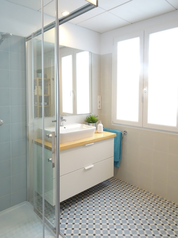 Inspiration for a mid-sized scandinavian 3/4 blue tile and ceramic tile ceramic tile and blue floor bathroom remodel in Alicante-Costa Blanca with furniture-like cabinets, white cabinets, a one-piece toilet, white walls, a vessel sink and wood countertops